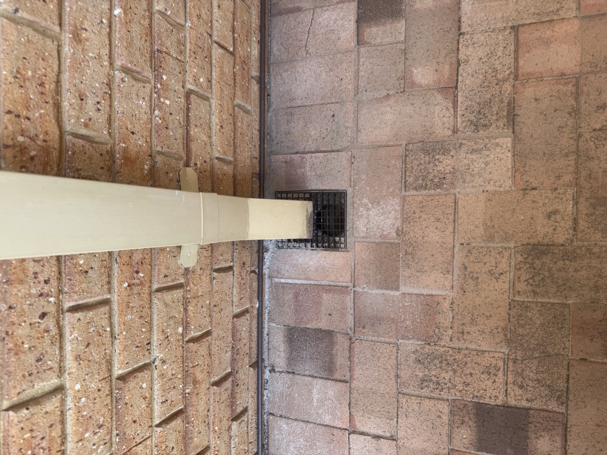 Downpipe connected into driveway drainage grate